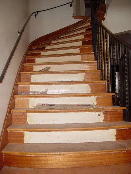 Curved staircase with worn oak treads and partly painted wood risers